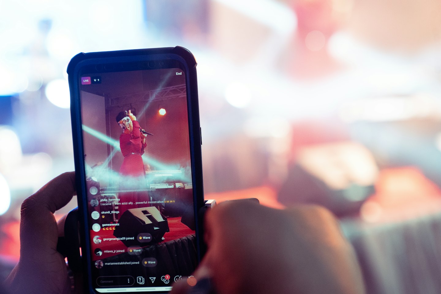 Hands holding a smartphone showing a live musical performance.