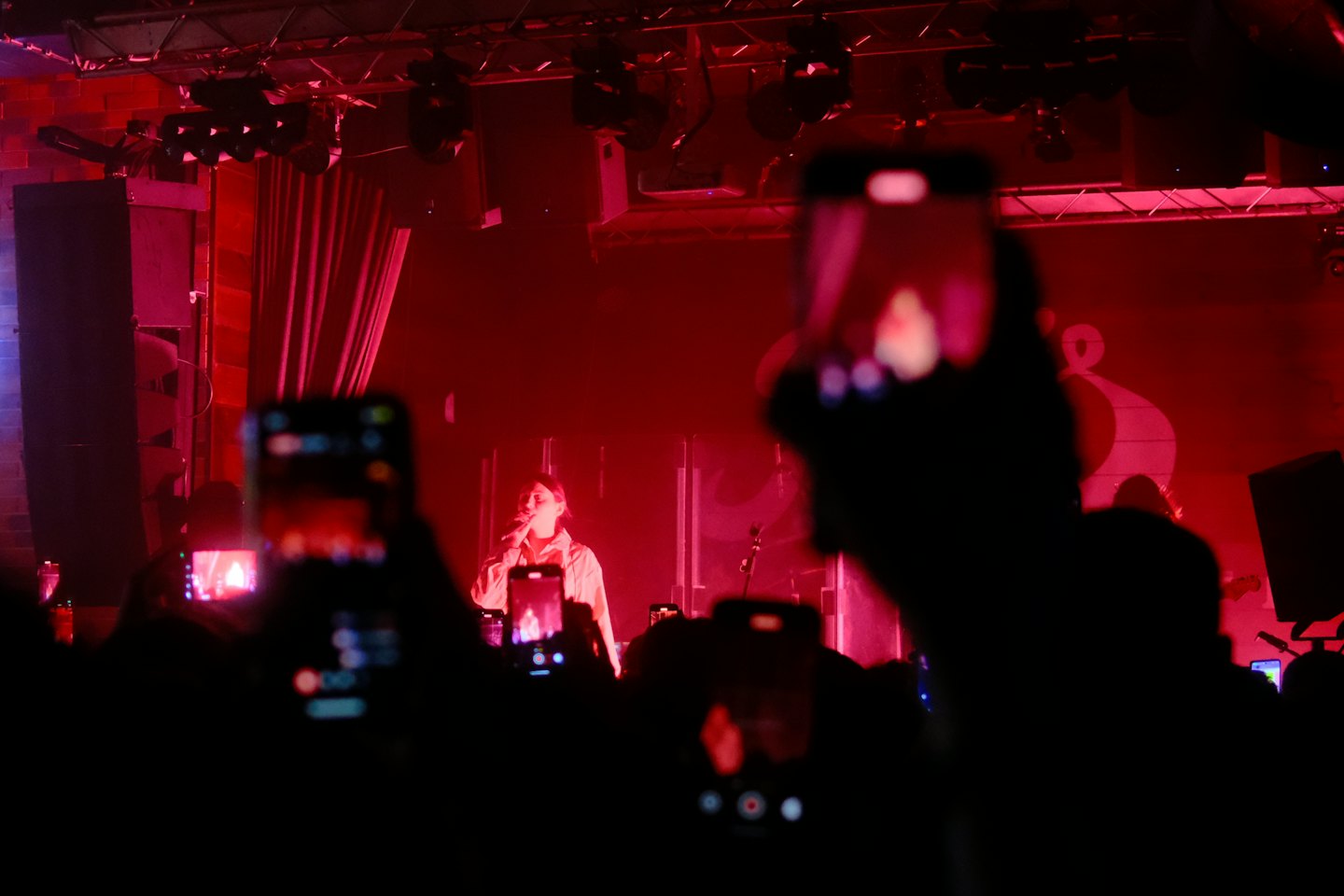 A singer performs into a microphone on a stage.